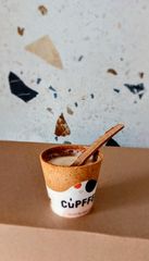 Foto van onze eetbare koffiebekers met een eetbare roerstaaf