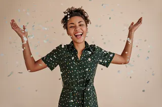 Positive african american woman smiling confetti studio shot goodhumoured black girl expressing happiness