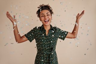 Positive african american woman smiling confetti studio shot goodhumoured black girl expressing happiness